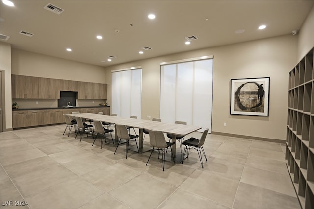 kitchen with a center island with sink, a breakfast bar, and light tile patterned floors