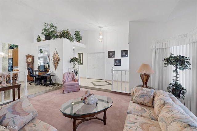 carpeted living room featuring a towering ceiling