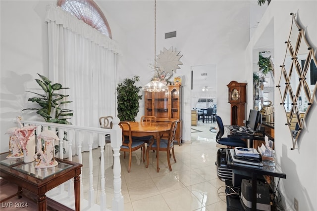 dining room with a high ceiling and light tile patterned floors