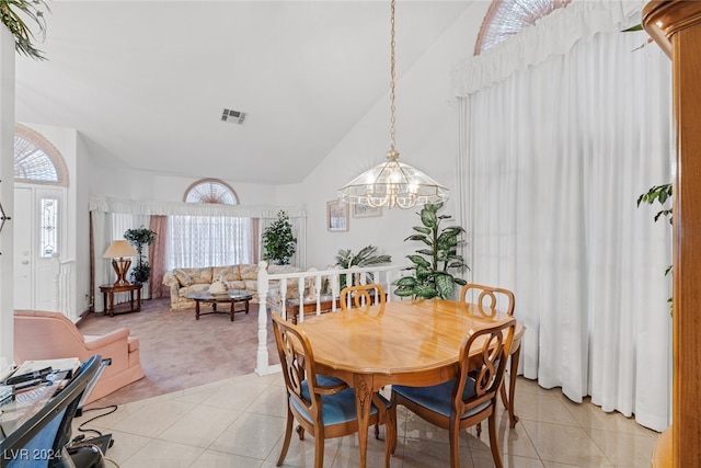 dining space featuring light colored carpet, lofted ceiling, and a chandelier