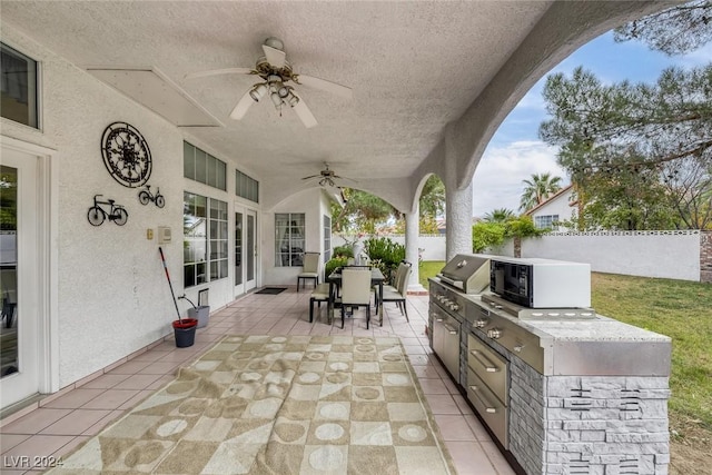 view of patio featuring ceiling fan, a grill, and exterior kitchen