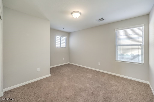 unfurnished room featuring light colored carpet