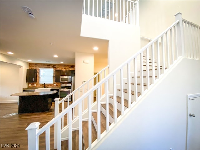 stairway with hardwood / wood-style flooring and sink