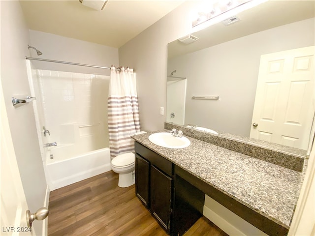 full bathroom featuring hardwood / wood-style floors, vanity, shower / tub combo, and toilet