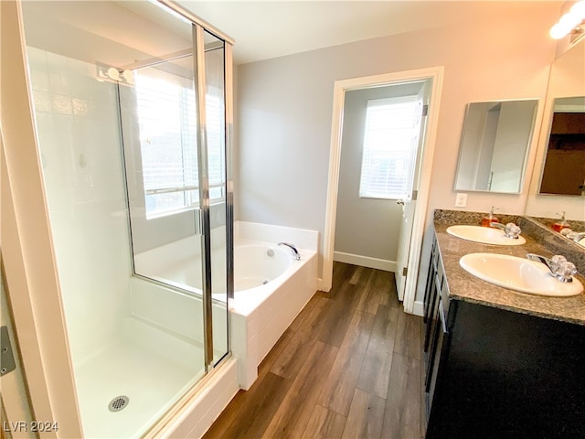 bathroom with vanity, hardwood / wood-style floors, and plus walk in shower