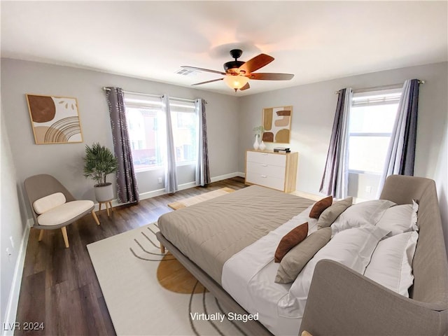 bedroom with dark hardwood / wood-style flooring, multiple windows, and ceiling fan