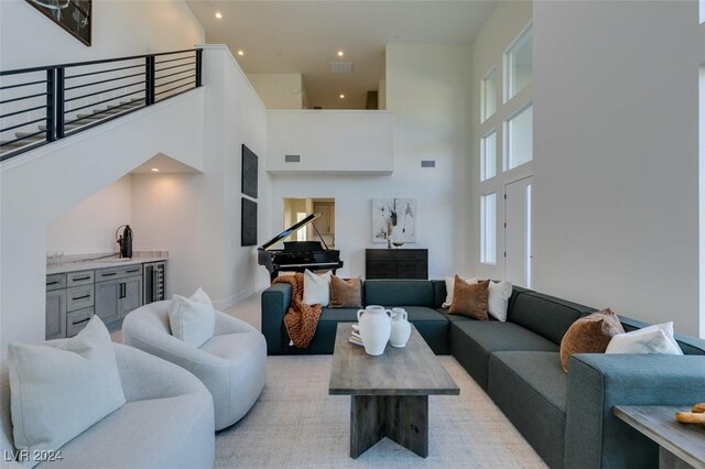 carpeted living room featuring a towering ceiling