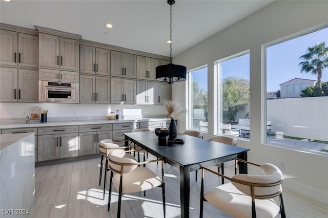 kitchen featuring decorative light fixtures, light hardwood / wood-style floors, and appliances with stainless steel finishes