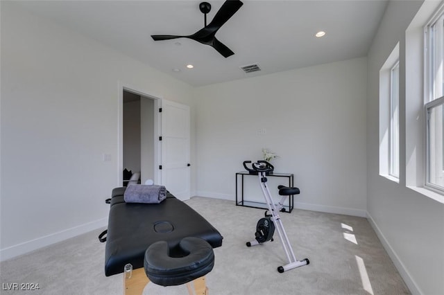 workout area featuring ceiling fan and light colored carpet