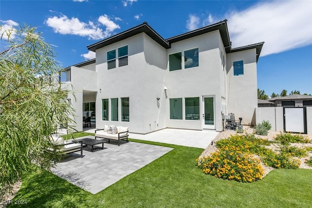 back of property with a patio area, an outdoor living space, and a yard