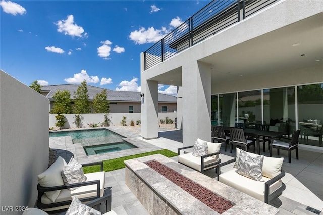 view of patio / terrace featuring a swimming pool with hot tub, a balcony, and an outdoor hangout area