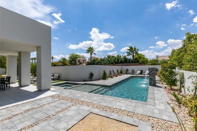 view of swimming pool with pool water feature, an in ground hot tub, and a patio