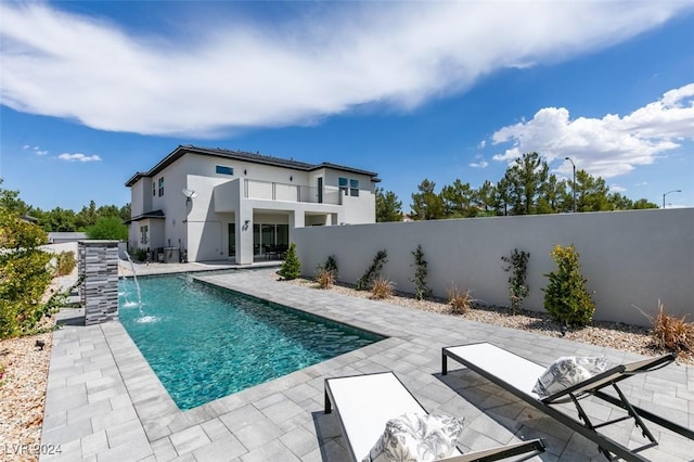 view of swimming pool with pool water feature and a patio