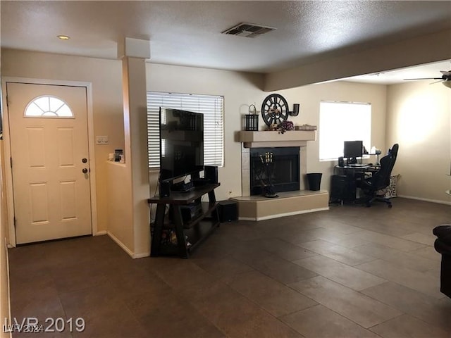 living room featuring a fireplace, a wealth of natural light, and ceiling fan