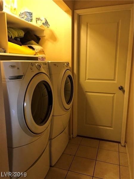 clothes washing area with light tile patterned floors and independent washer and dryer