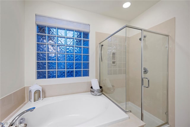 bathroom featuring shower with separate bathtub