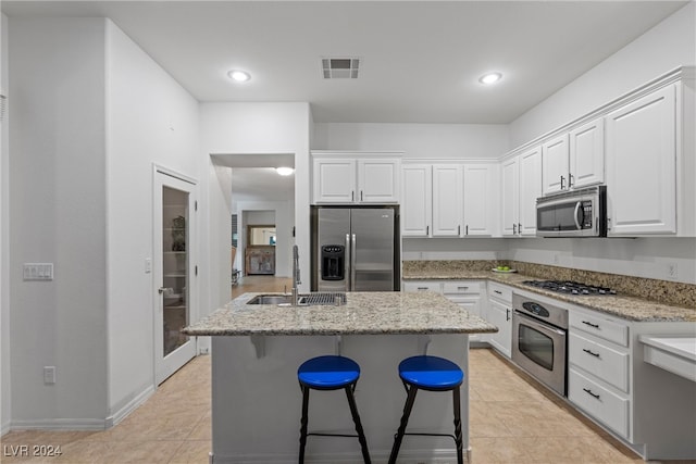 kitchen with white cabinets, appliances with stainless steel finishes, a kitchen island, and sink