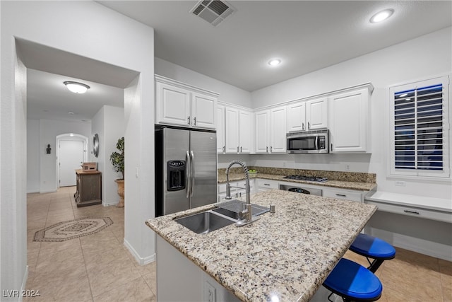 kitchen with a kitchen island with sink, sink, white cabinets, and appliances with stainless steel finishes