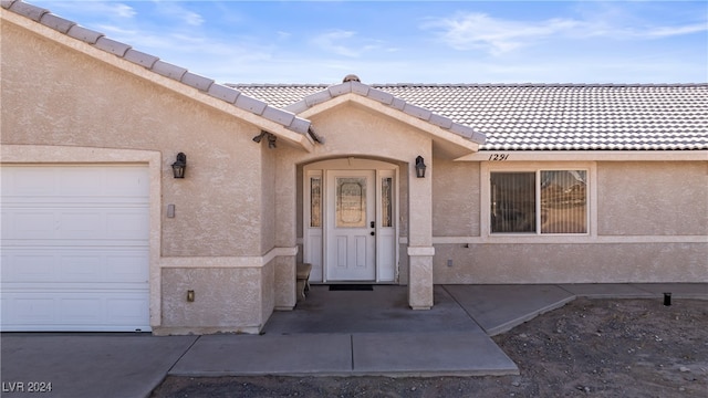 view of exterior entry with a garage