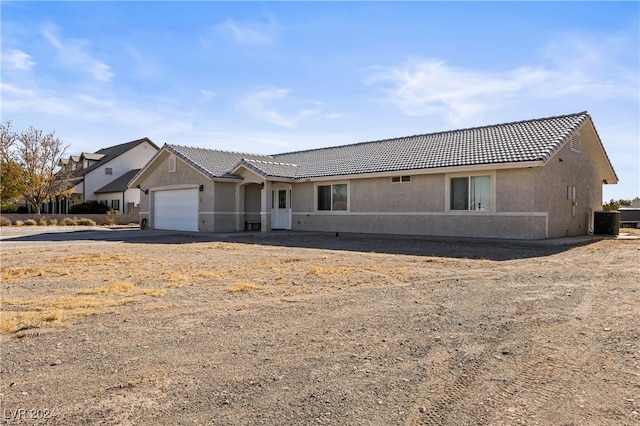 view of front of property with a garage and central AC unit