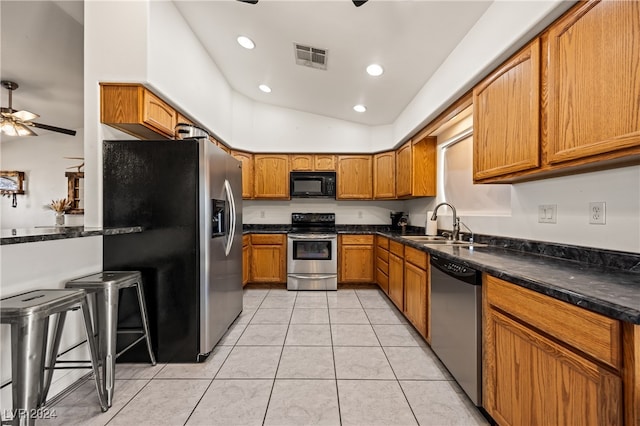 kitchen featuring ceiling fan, sink, stainless steel appliances, vaulted ceiling, and light tile patterned floors