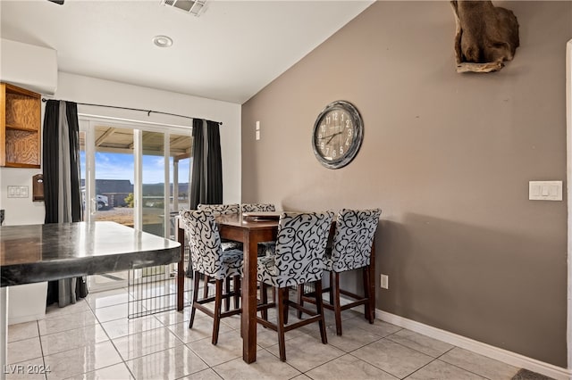 dining room with light tile patterned flooring and lofted ceiling