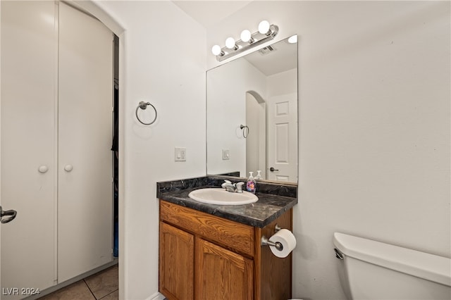 bathroom featuring tile patterned flooring, vanity, and toilet