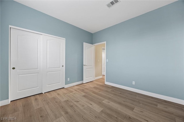 unfurnished bedroom featuring light hardwood / wood-style floors and a closet