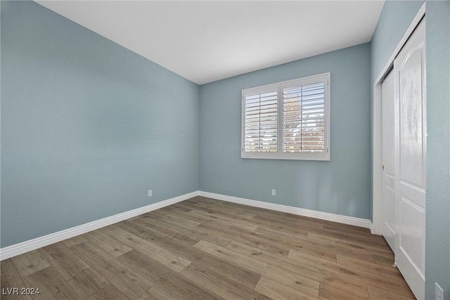 unfurnished bedroom with light wood-type flooring and a closet