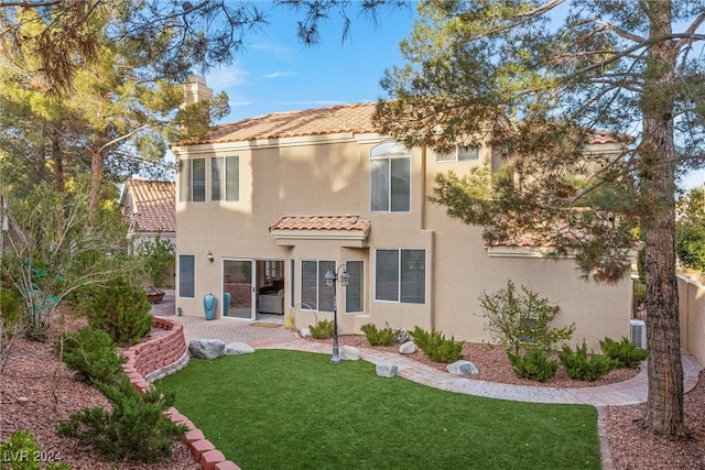 rear view of house featuring a lawn, a patio, and central AC unit