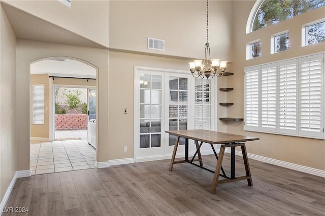 dining space with hardwood / wood-style flooring and an inviting chandelier