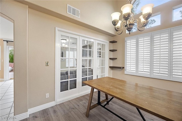 dining area with wood-type flooring and a notable chandelier