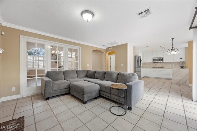 living room featuring a chandelier, crown molding, and light tile patterned flooring