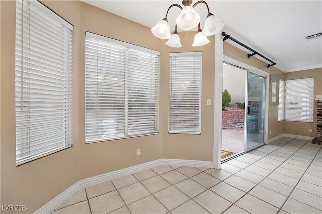 unfurnished dining area with light tile patterned floors, ornamental molding, and an inviting chandelier