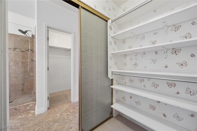 bathroom with tile patterned floors and a tile shower