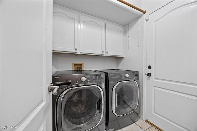 laundry area featuring cabinets, light tile patterned floors, and separate washer and dryer