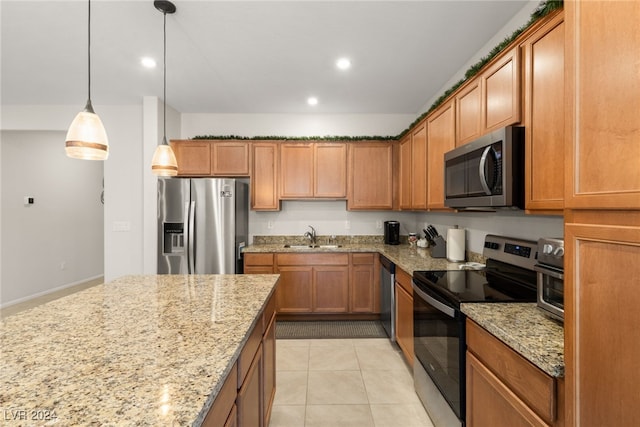 kitchen featuring appliances with stainless steel finishes, light stone counters, sink, light tile patterned floors, and pendant lighting