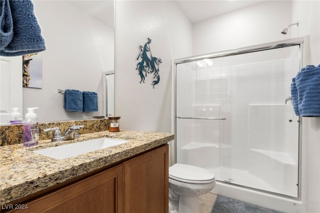 bathroom with vanity, a shower with shower door, and toilet