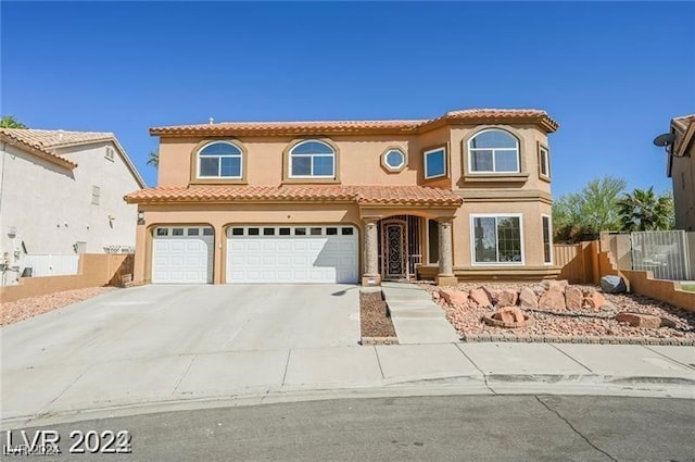 mediterranean / spanish-style home with a garage