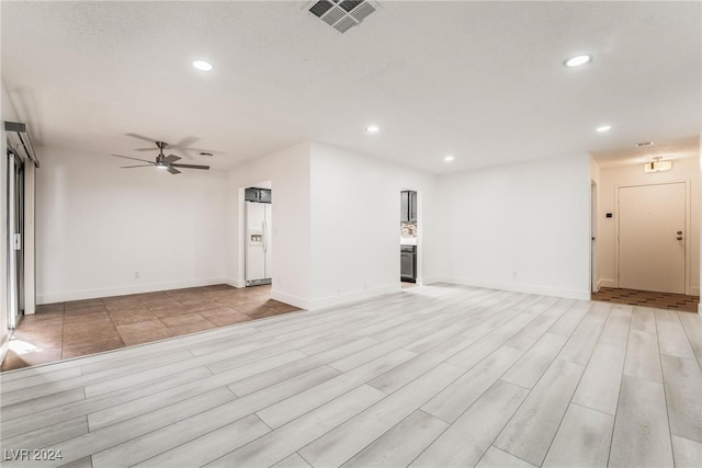 unfurnished living room featuring ceiling fan and light hardwood / wood-style floors