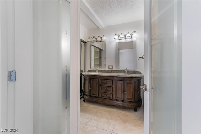 bathroom with a textured ceiling, vanity, and tile patterned floors