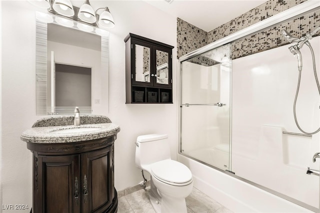 full bathroom featuring tile patterned flooring, vanity, toilet, and bath / shower combo with glass door