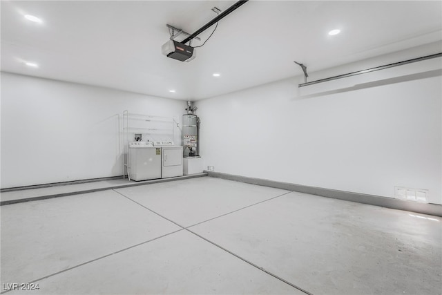 garage featuring strapped water heater, a garage door opener, and independent washer and dryer