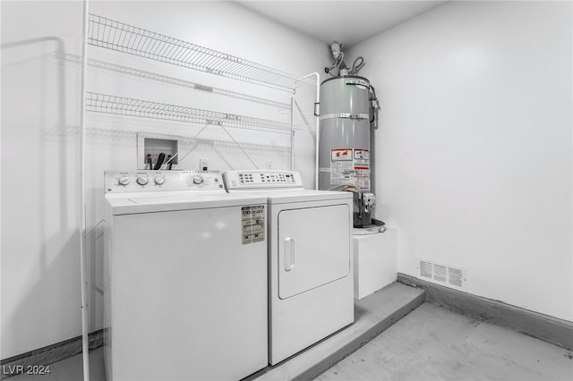 laundry area featuring secured water heater and separate washer and dryer