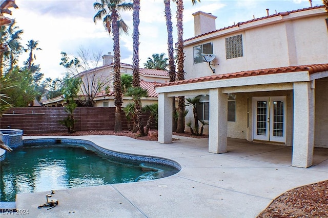 view of swimming pool with a patio and french doors