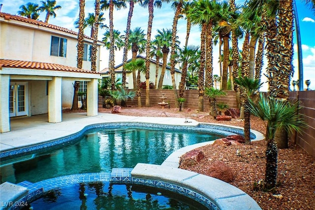 view of swimming pool featuring an in ground hot tub and a patio area