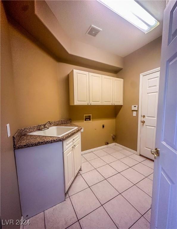 clothes washing area with sink, light tile patterned floors, hookup for a washing machine, cabinets, and hookup for an electric dryer