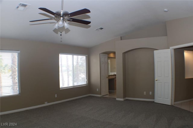 carpeted spare room featuring vaulted ceiling and ceiling fan