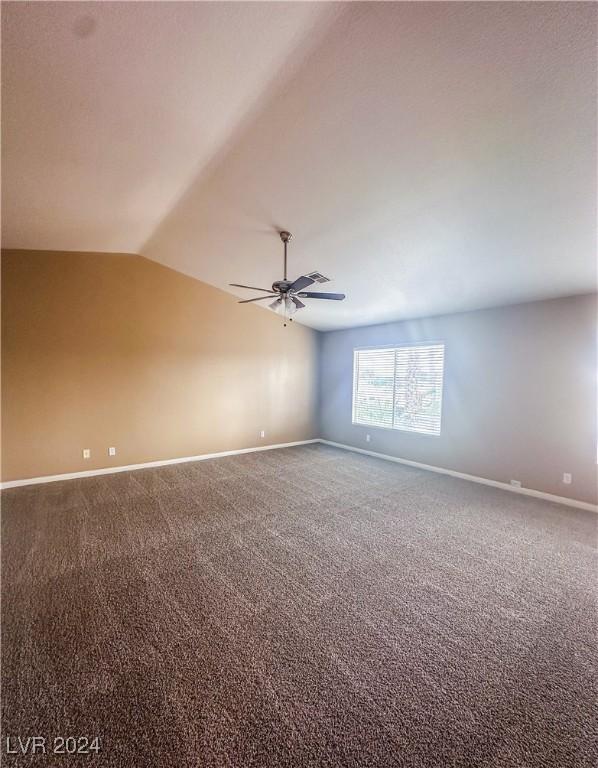 carpeted spare room with lofted ceiling and ceiling fan