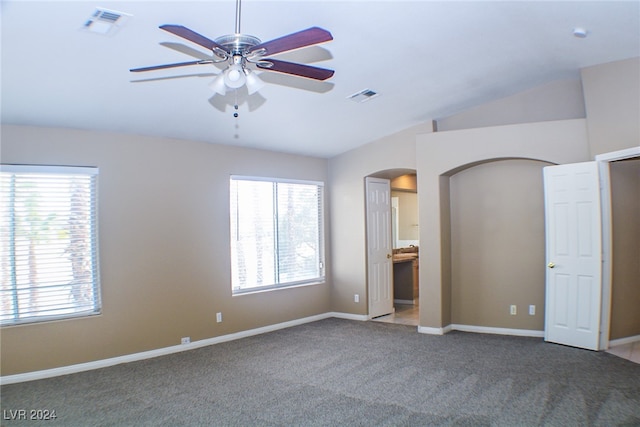 unfurnished bedroom featuring vaulted ceiling, carpet flooring, ceiling fan, and ensuite bath